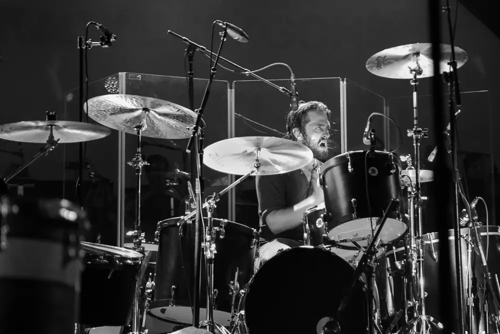 Daniel Platzman playing a black drum set with Zildjian cymbals.